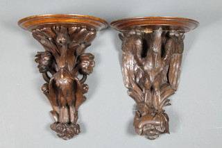 A pair of 19th Century Black Forest carved oak wall brackets decorated with exotic birds on fish 15" ILLUSTRATED