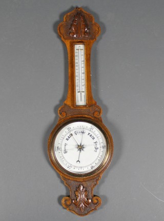 An Edwardian barometer/thermometer contained in a carved oak banjo case