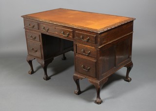 A carved oak pedestal desk with 3 drawers above 2 drawers to each pedestal, raised on cabriole legs with claw and ball feet 31.5" x 48" x 27"