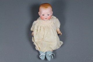 An Armand Marseille porcelain headed doll with open and shutting eyes, open mouth with 2 teeth, the head incised AM Germany 351/7K ILLUSTRATED