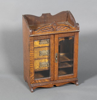 An Edwardian carved oak smokers companion with bevelled doors and fitted interior 13"