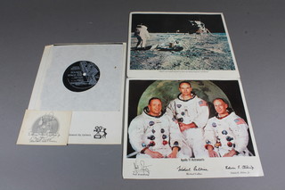 2 colour photographs of The Apollo 11 astronauts with facsimile signatures 8.5" x 10" and 1 other photograph of the Moon Landing, a National Geographical record - Sound of the Space Age and an Apollo 11 sticker - bears signature