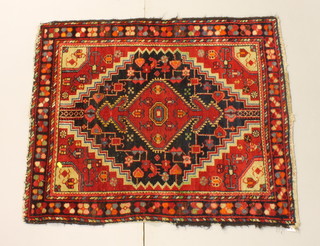 A North West Persian red ground rug with diamond to the centre 43 1/2" x 35"