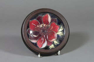 A Moorcroft dish decorated with a anemone mounted in a circular oak frame 4" 