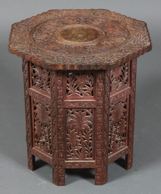 An octagonal pierced and carved hardwood occasional table, raised on a folding stand 19"h x 18"w