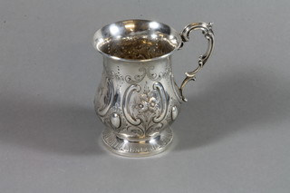 A mid Victorian silver repousse baluster mug with scroll handle, London 1861, maker Thomas Streetin