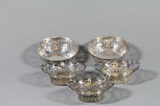 A set of 3 repousse pierced silver bon bon dishes and a pair of circular silver ditto 