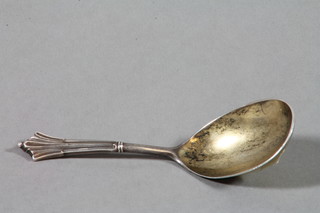 A silver caddy spoon with fancy handle