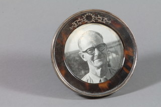A circular silver and tortoishell photograph frame 4.25" diam.