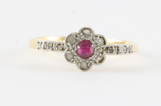 An 18ct gold dress ring set rubies surrounded by diamonds