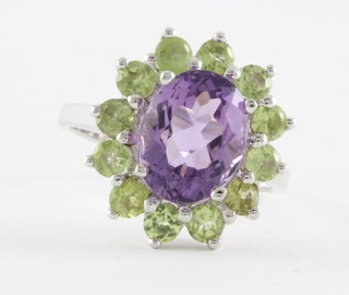A silver dress ring set a purple amethyst surrounded by peridots, approx 5ct
