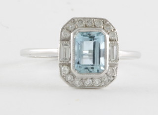 An 18ct white gold dress ring set an aquamarine surrounded by diamonds 