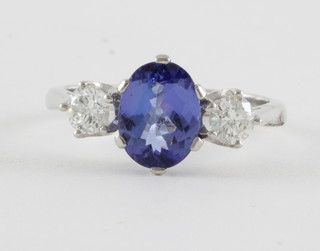 An 18ct white gold dress ring set an oval tanzanite supported by 2 diamonds approx. 2ct/0.55ct 