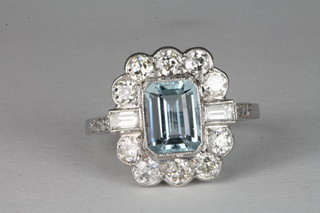 An 18ct white gold dress ring set a rectangular cut aquamarine surrounded by diamonds ILLUSTRATED