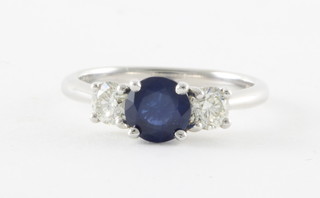 An 18ct white gold dress ring set a circular cut sapphire, approx 1.20ct, supported by 2 diamonds approx. 0.59ct 