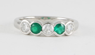 An 18ct white gold dress ring set emeralds approx. 0.29ct and diamonds approx. 0.52ct