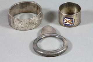 An engraved silver bangle, a silver magnifying glass and a silver napkin ring
