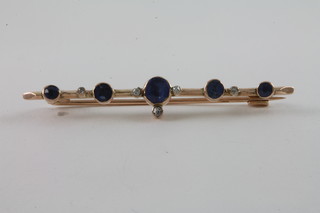 A lady's gold bar brooch set 5 sapphires supported by diamonds