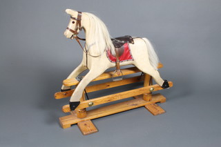 A polychrome carved wood rocking horse on a pine base 33" x 36"