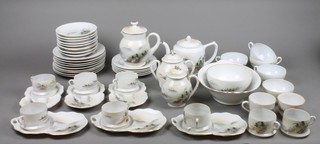 An extensive Japanese egg shell porcelain tea and coffee service decorated with views of Mount Fuji comprising 8 fireside cups (2f) and 6 saucers, 2 cups (1f), 2 saucers, 5 cups, 7 saucers, 5 plates, 9 large plates (1f) teapot and lid, milk jug and lid, waterjug and lid, slop bowl and lid, sugar bowl and oval dish (f)