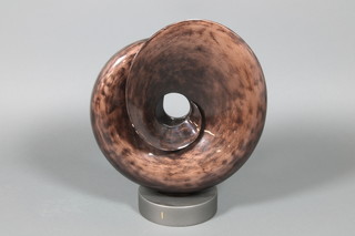 A brown plastic sculpture of a stylised shell, raised on a circular base 19" 