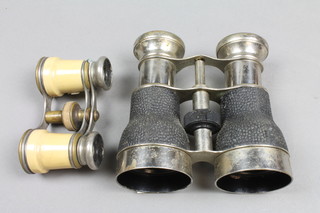 A pair of opera glasses and a pair of binoculars in a chrome case