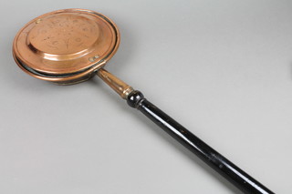 A copper warming pan with turned ebonised handle