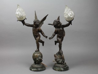 A pair of 19th Century French spelter table lamps in the form of cherubs with torches, raised on circular green marble bases 20" 