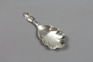 A silver caddy spoon with scalloped bowl and fancy handle, Sheffield 1961