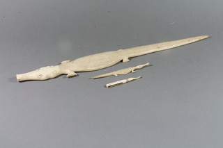 A carved ivory figure of a crocodile 11", 1 other 6" and an ivory tweezers