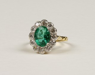 An 18ct yellow gold oval emerald and diamond cluster ring, approx. 2.40ct emerald and 1.05ct diamonds 