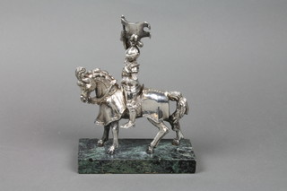 A filled silver figure of a knight on horse back, raised on a green marble base 8"