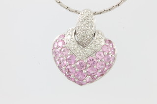 An 18ct white gold diamond and pink sapphire set heart pendant hung on an 18ct white gold chain