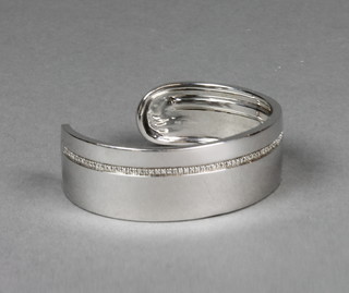 A contemporary diamond set silver bangle