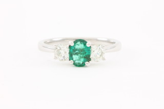 An 18ct white gold claw set oval cut emerald approx. 0.53ct and 2 stone diamond approx 0.57ct ring