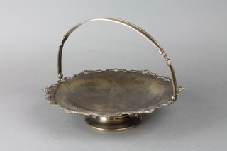 An early 20th Century silver swing handled basket with Chippendale and shell rim 11", marks rubbed, 16 ozs
