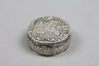 A 19th Century Dutch repousse circular snuff box with rural scene and scrolling foliage 2"