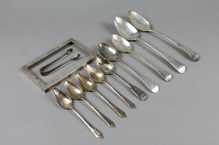 A pair of silver pudding spoons, 4 silver grapefruit spoons, a pair of silver tongs and a rectangular plain silver frame 6" x 4" 