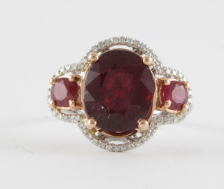A 14ct yellow gold dress ring set an oval cut ruby, approx 7.5ct flanked by 2 round cut rubies approx. 1.5ct, supported by diamonds approx. 0.5ct