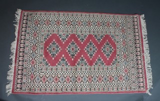 A Persian pink ground rug with 4 diamonds to the centre within multi-row borders 58" x 37"