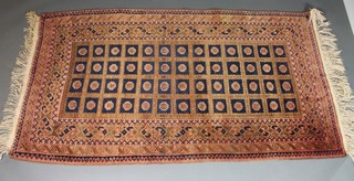 An Afgan red ground rug with 52 stylised octagons to the centre 81" x 44" 