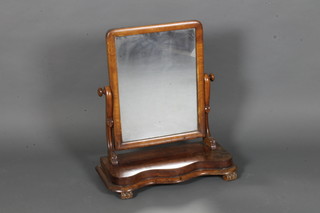 A Victorian rectangular plate toilet mirror contained in a  mahogany swing frame, the base of serpentine outline, 24"h x  22"w x 10"d