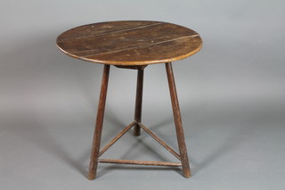A 19th Century circular elm cricket table, raised on turned supports 29"h x 28" diam.