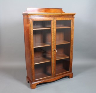 A Victorian mahogany display cabinet with raised back, the interior fitted 2 shelves enclosed by glazed panelled doors, raised on bracket feet 57 1/2"h x 38"w x 14"d 