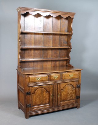 A 17th Century style oak dresser, the raised back with cornice above 4 shelves and 1 short and 2 long drawers, the base fitted a double cupboard, 78"h x 79"w x 21 1/2"d