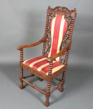 A Victorian oak Carolean style elbow chair with bobbin turned decoration, pierced and carved back, upholstered seat, raised on  turned and block supports