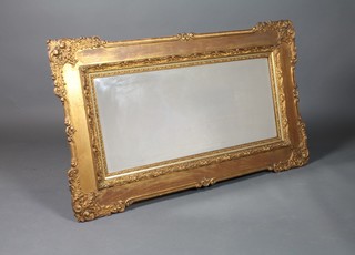 An Art Nouveau rectangular plate wall mirror contained in a decorative gilt frame 55" x 43" 