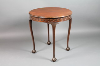 An Edwardian circular mahogany occasional table with carved apron, raised on ball and claw supports 28 1/2"h x 27"diam. 