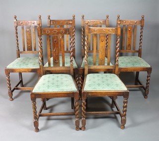 A set of 6 1930's carved oak splat back dining chairs with spiral turned columns and upholstered drop in seats, raised on turned and block supports with H framed stretchers