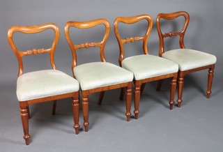 A set of 4 Victorian mahogany buckle back dining chairs with carved mid rails and upholstered seats, raised on chamfered legs